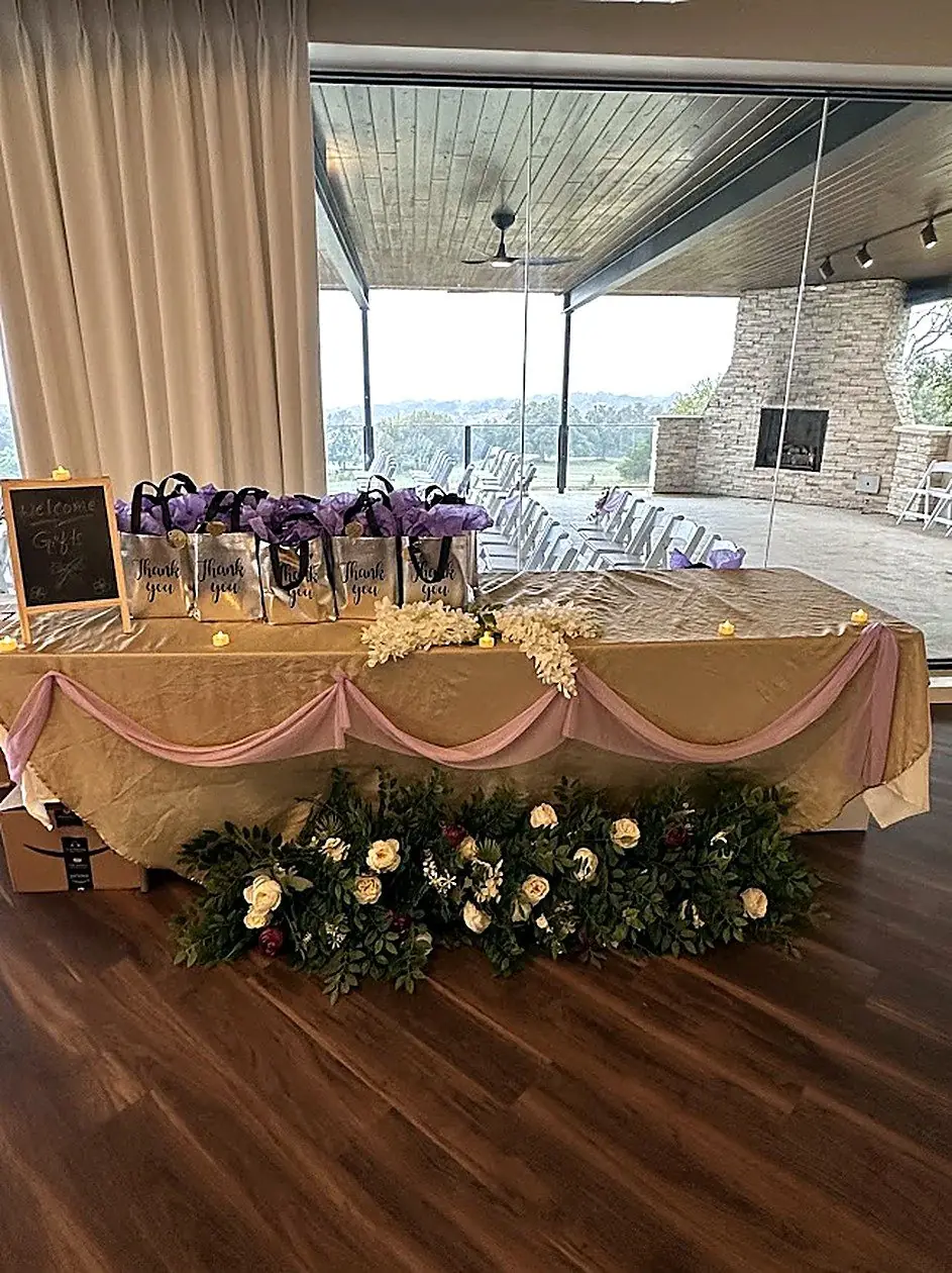Sweetheart and gift table draped in gold and blush with a lush white floral garland by Bsquare Events